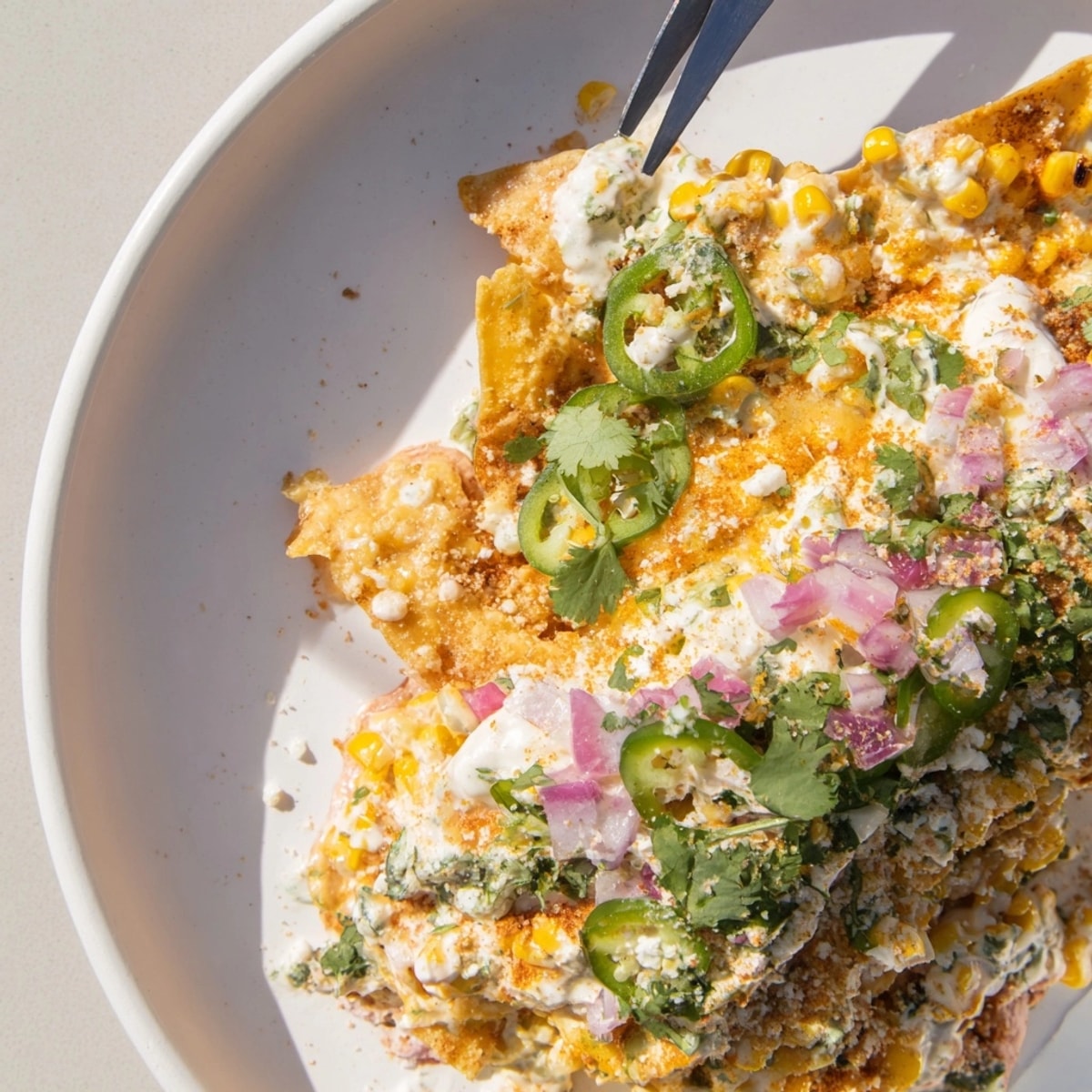 Golden Elote Nachos piled high, showcasing melted cheese, bright cilantro, and charred corn.