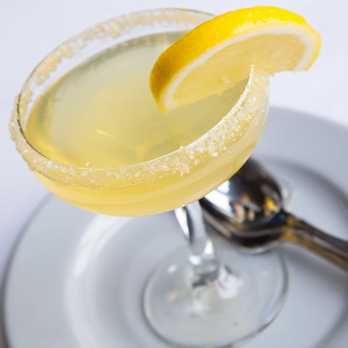 A chilled Lemon Drop, garnished with a lemon twist, looks refreshing and delicious.