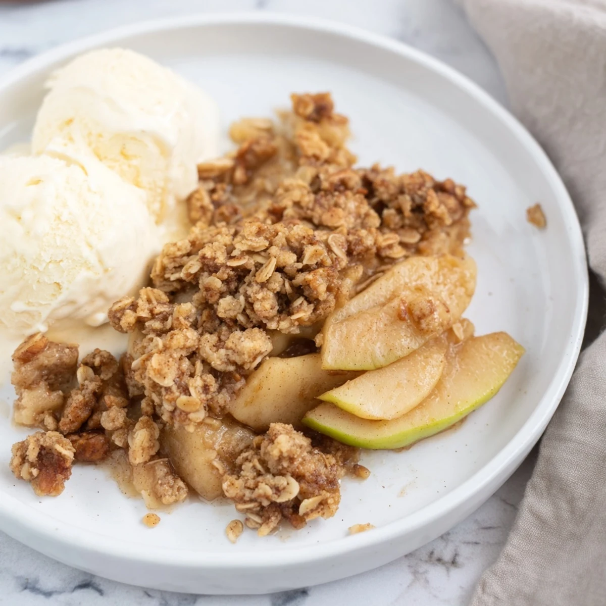 Close-up of freshly baked Warm Apple Crisp, showing the tender apples and oat crumble.