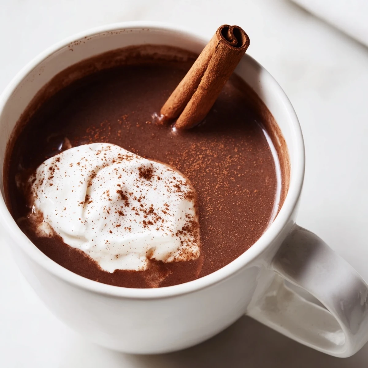 Steaming Spiced Hot Chocolate with cinnamon stick garnish – a warm, comforting beverage.