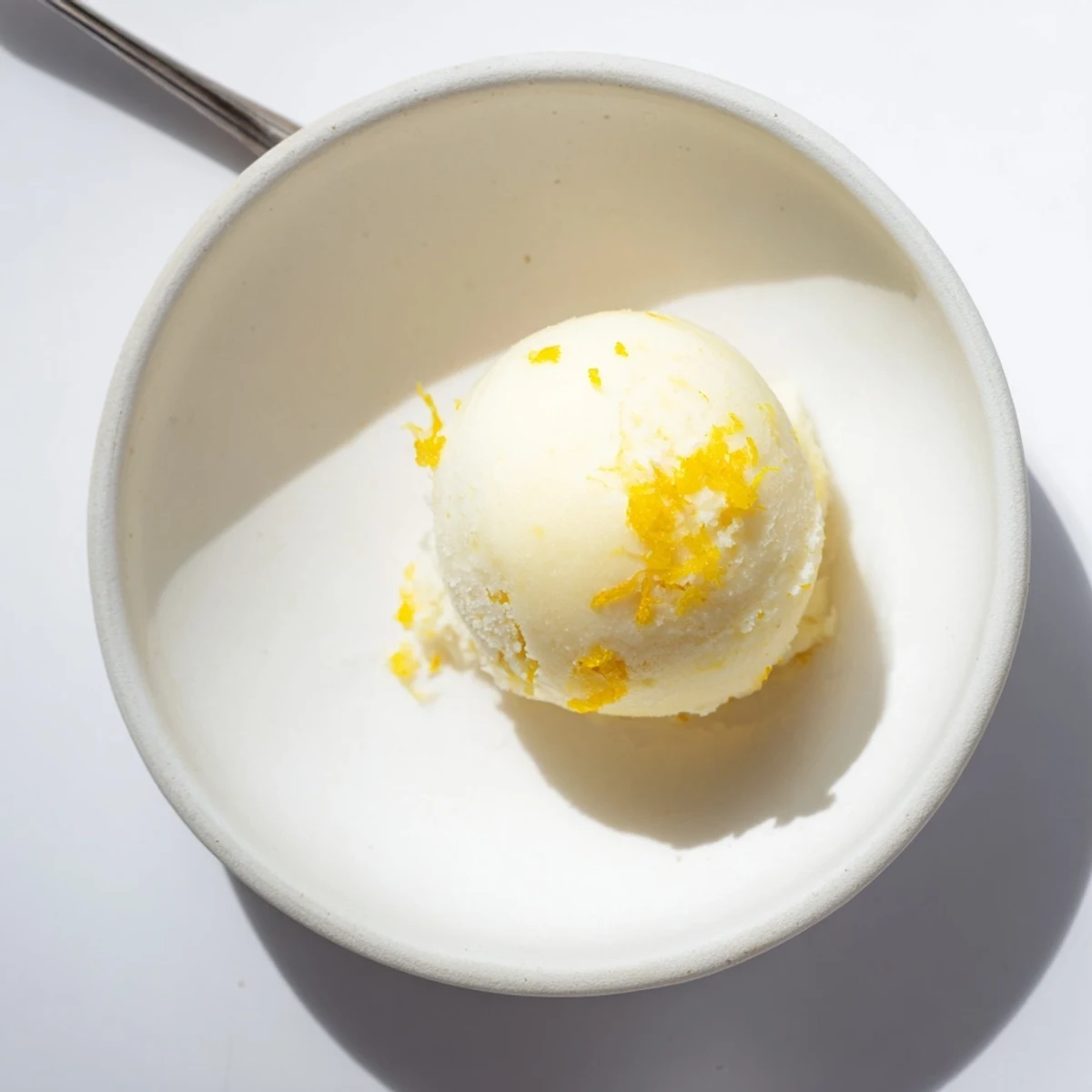 A vibrant scoop of lemon sorbet, cold and tart, perfect for a summer dessert.