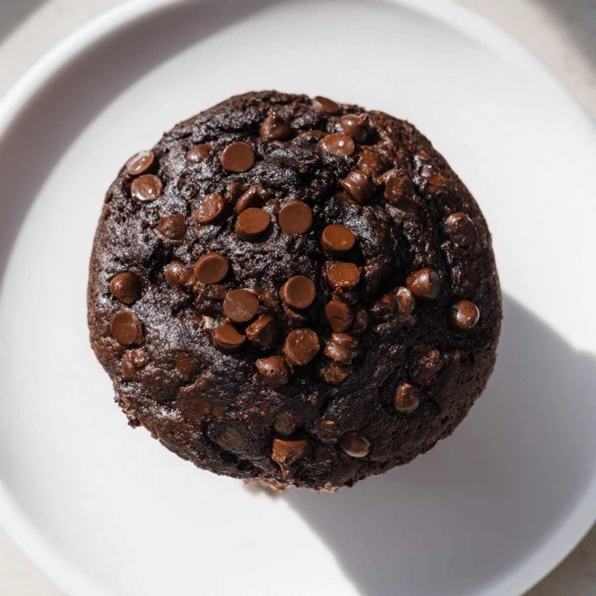 Close-up of decadent chocolate muffin tops, ready to eat, with a dusting of extra chocolate.