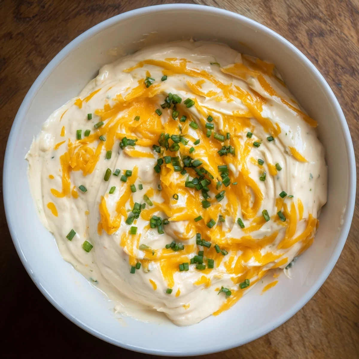 Warm and creamy cheese dip with melted cheddar, perfect for dipping tortilla chips at a party.