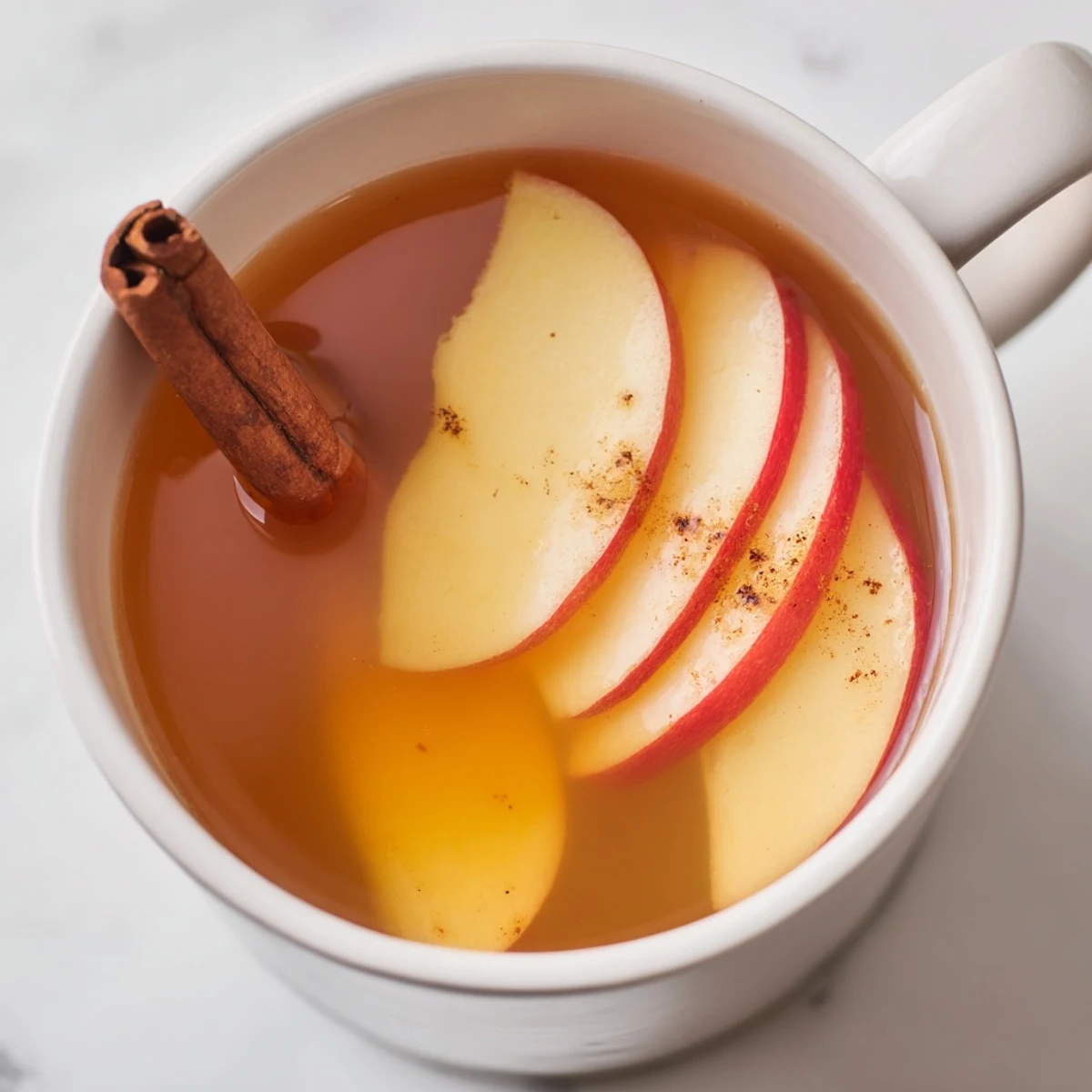 Picture of a mug filled with hot warm apple cider, the perfect cozy American beverage.