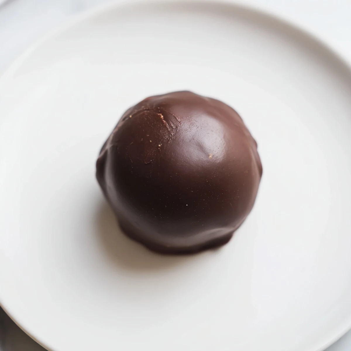 Smooth peanut butter balls, covered in glossy chocolate, offer a perfect sweet indulgence.