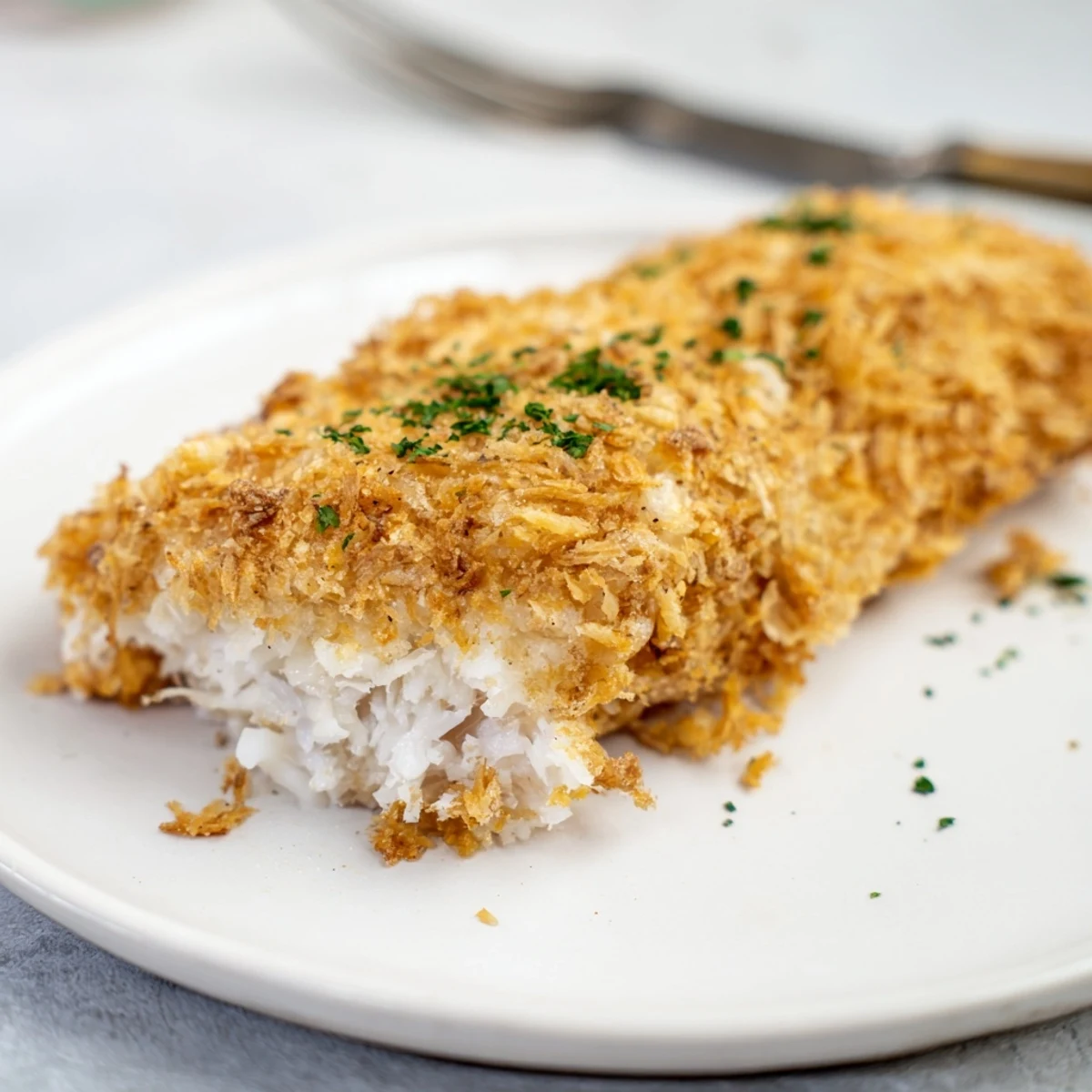 Enjoy a plate of crispy, perfectly cooked crumbed cod, a delicious main course option.