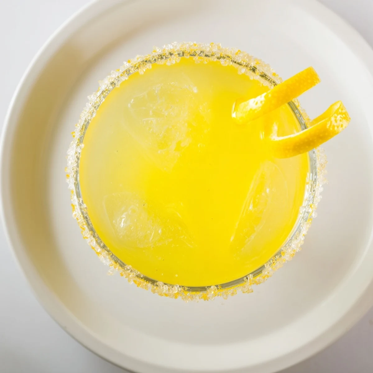 Brightly lit photo of a Drop Lemon, ice sparkling, ready for a warm evening, with fresh citrus.