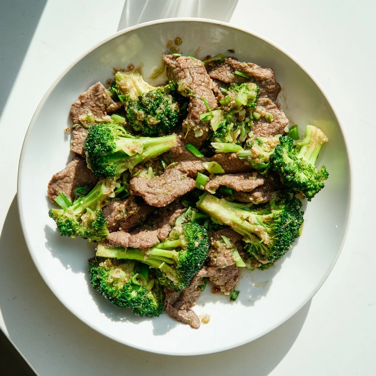 Steaming keto-friendly beef and broccoli stir fry, showcasing tender beef and crisp broccoli with savory sauce.