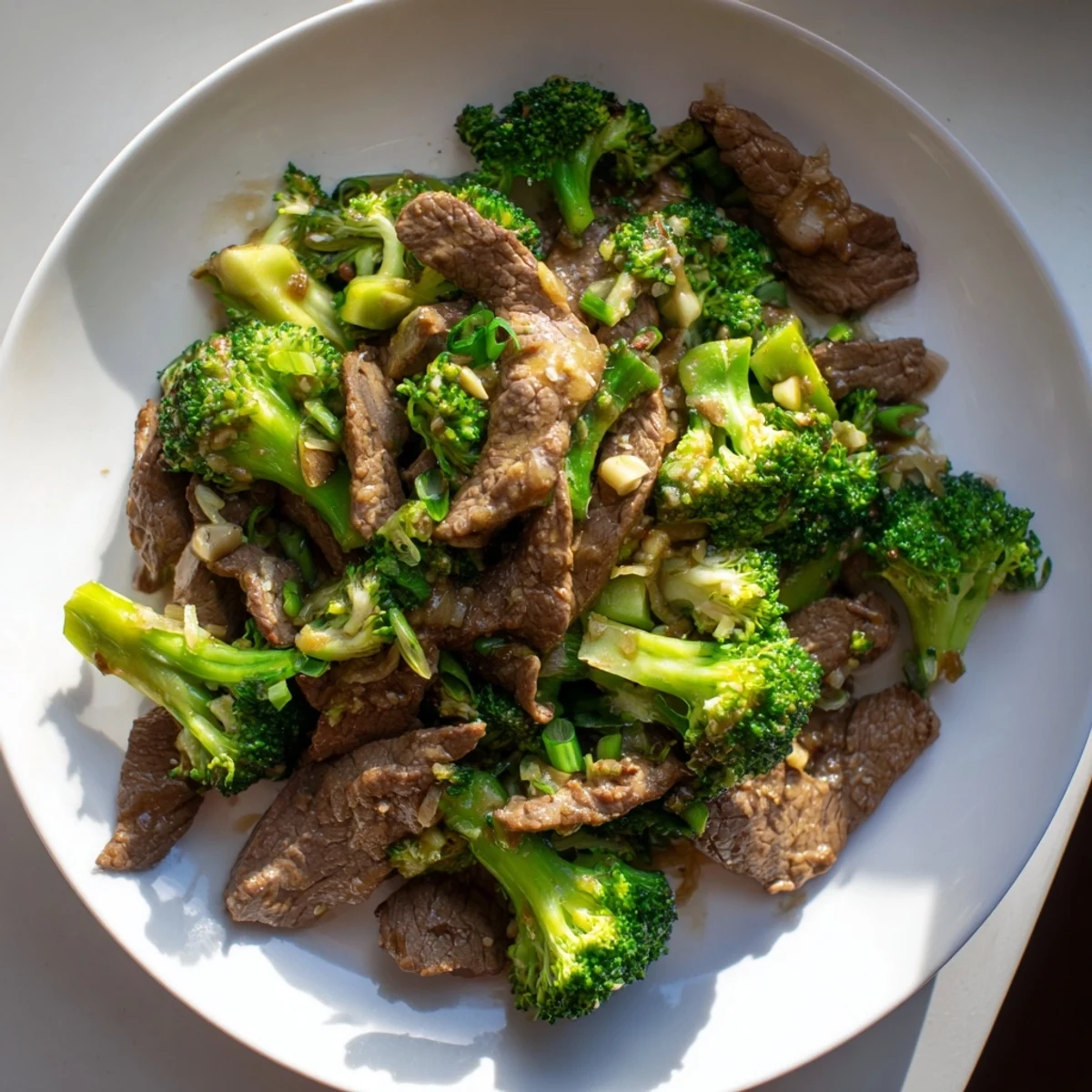 A steaming hot plate of keto friendly beef and broccoli stir fry, ready to eat with a rich brown sauce.
