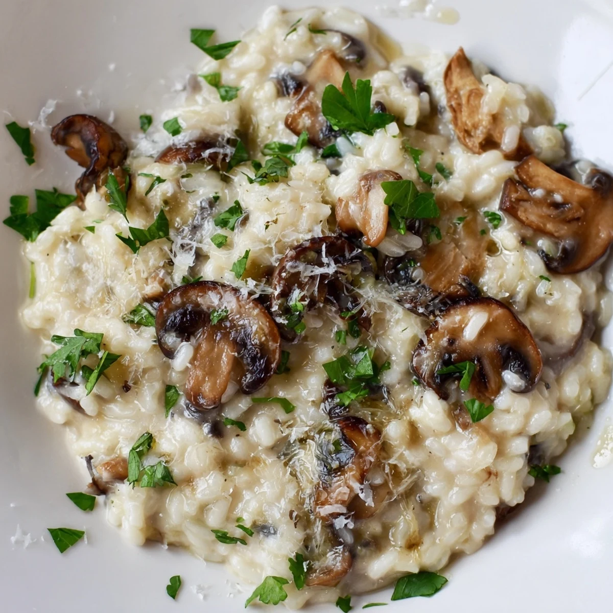 Spoon lifting a creamy serving of Creamy Mushroom Risotto with Truffle Oil, highlighting tender mushrooms.