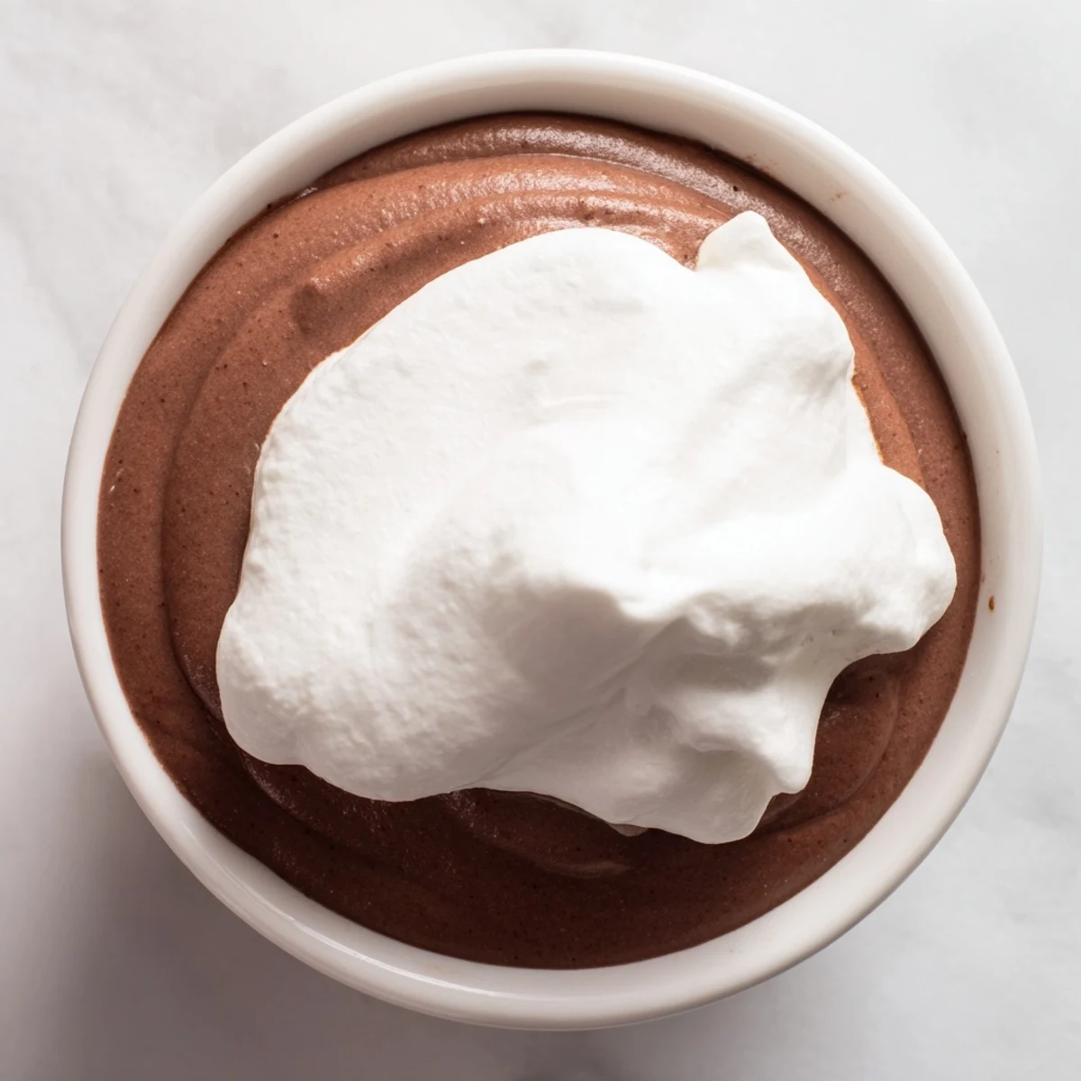 Homemade Chocolate Pudding with Whipped Cream served chilled, offering a smooth, creamy dessert finish.
