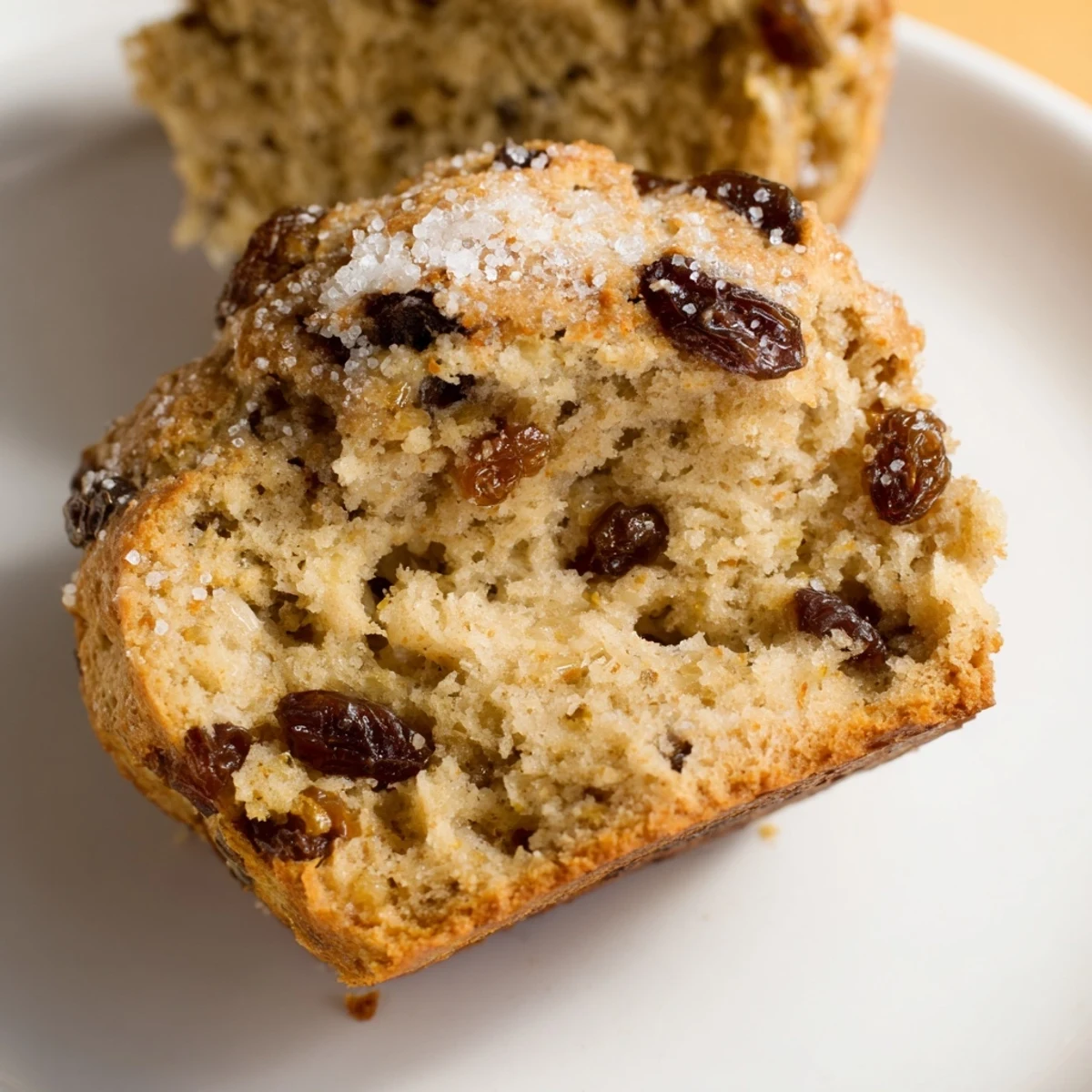 Stack of warm Irish Soda Bread Muffins with soft crumb and visible plump raisins.
