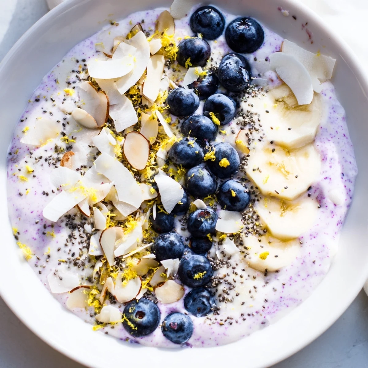 A vibrant Lemon Blueberry Smoothie Bowl topped with crunchy granola and fresh blueberries for a refreshing breakfast.