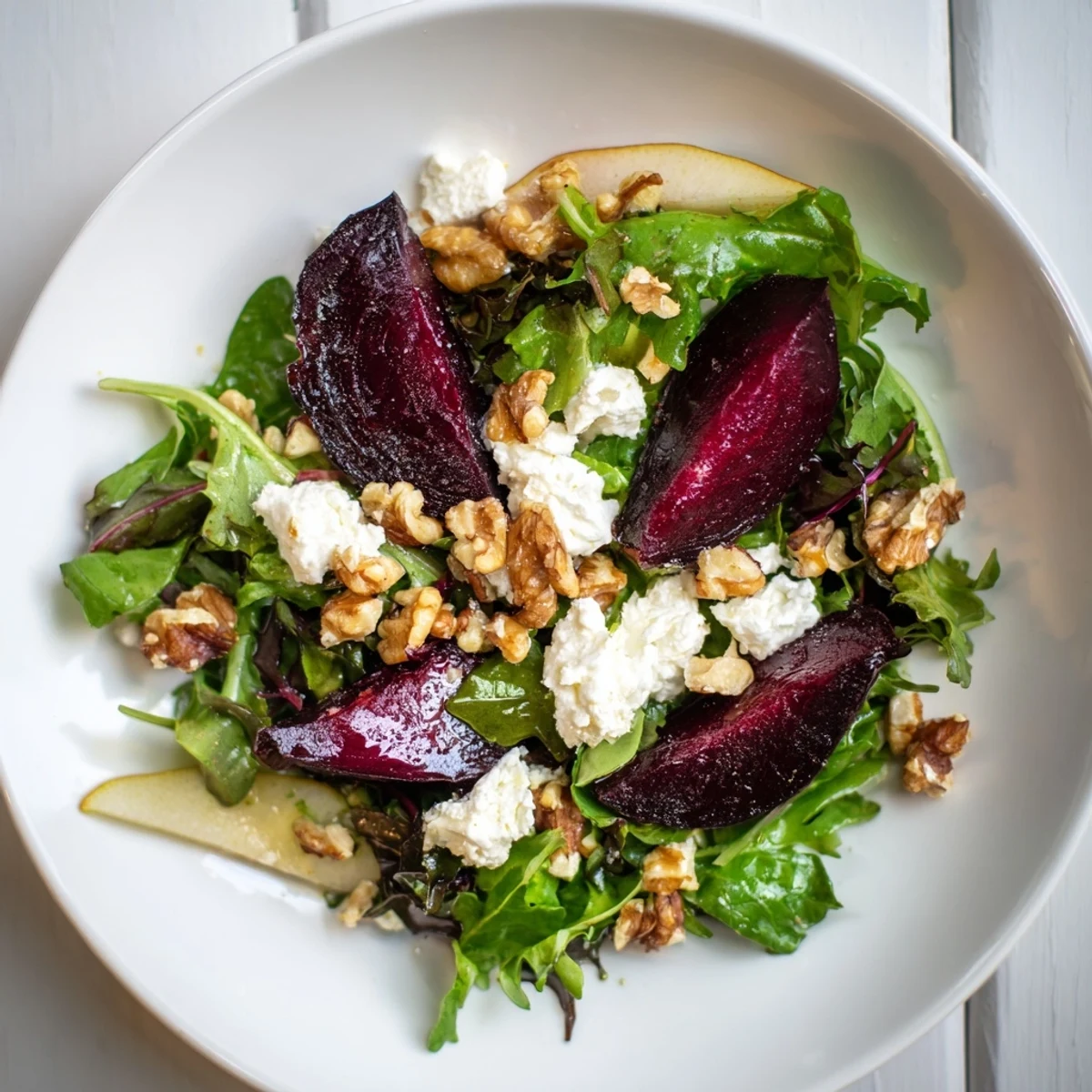 Sliced Roasted Beet Salad with Goat Cheese Crumbles drizzled with balsamic vinaigrette for a fresh appetizer.