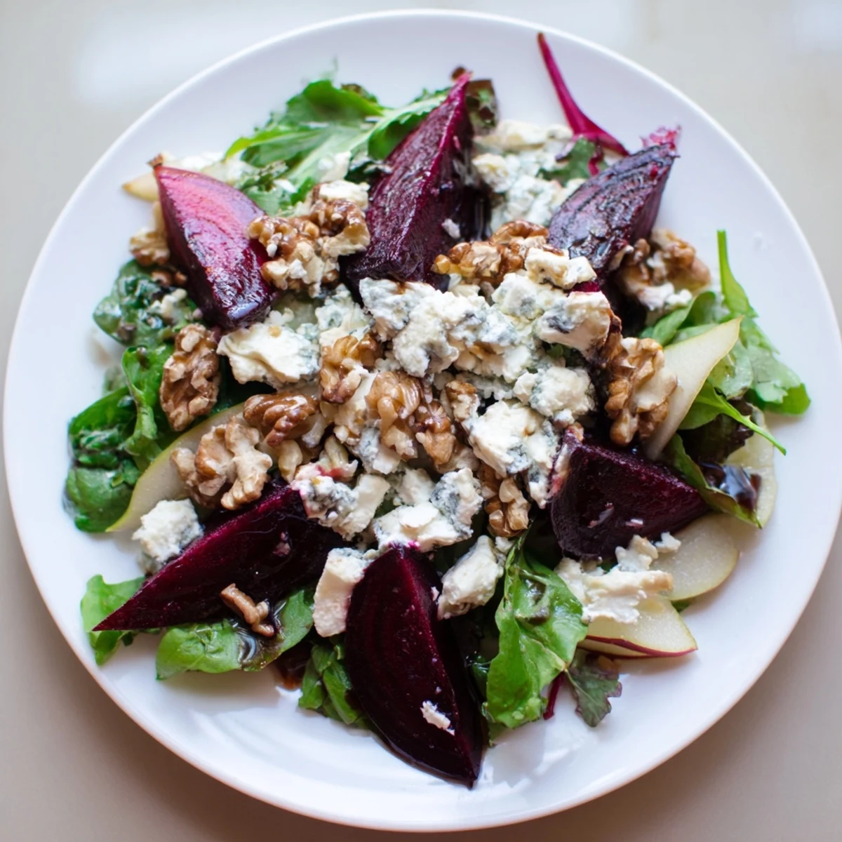 Roasted Beet Salad with Goat Cheese Crumbles served on vibrant mixed greens with toasted walnuts.