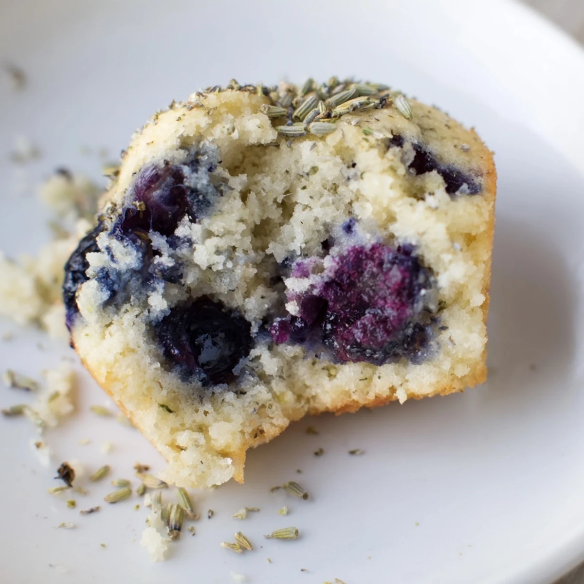 Tender Lavender Blueberry Tea Cakes dusted with powdered sugar alongside a steaming cup of Earl Grey tea.