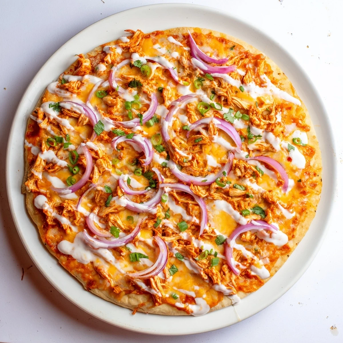 Sizzling Bold Buffalo Chicken Pizza on a wooden board, topped with scallions and cilantro, ready for a game day feast.
