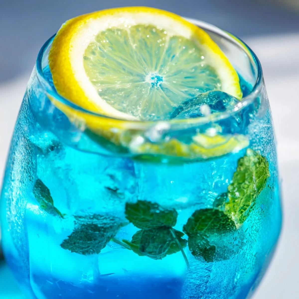 Blue Spirulina Lemonade served over ice in a tall glass with a refreshing citrus scent.