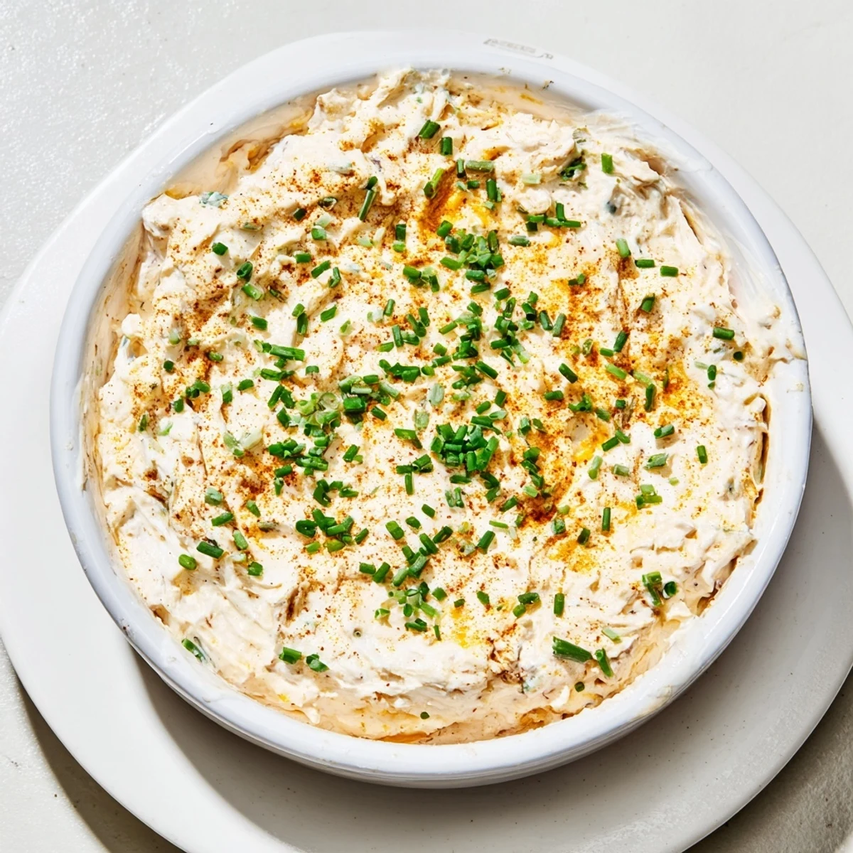 Golden soft pretzels arranged around a bowl of tangy homemade savory pretzel dip sprinkled with green onions