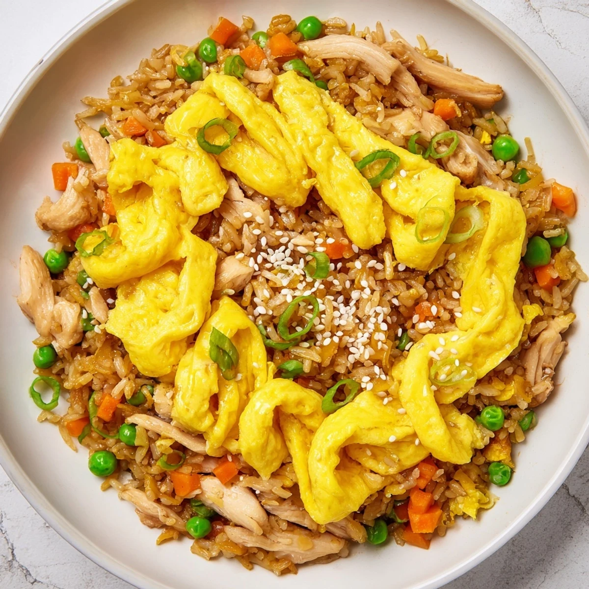 Sizzling chicken fried rice featuring tender sliced chicken, peas, carrots, and scrambled eggs