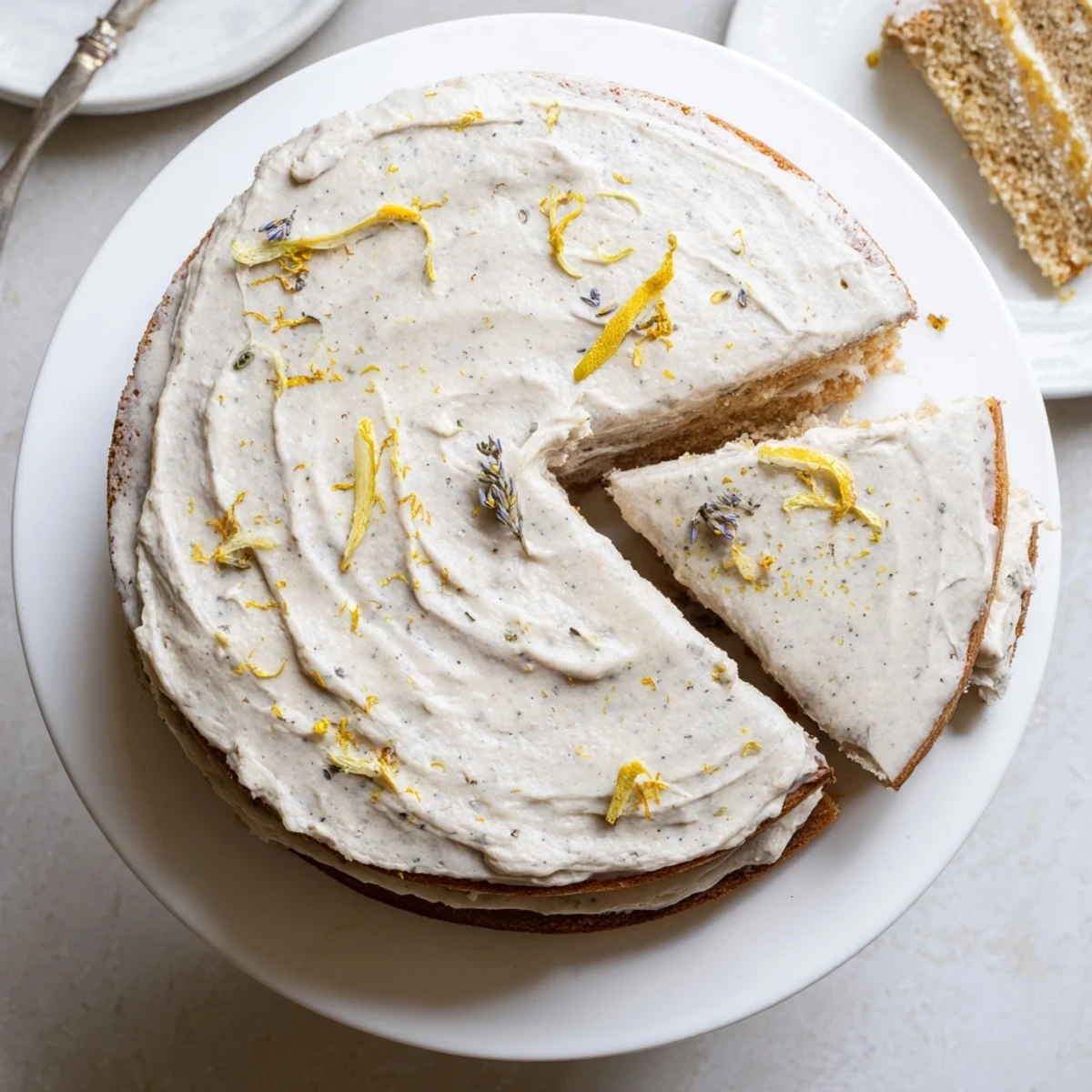 Three-layer London Fog cake with speckled vanilla bean frosting drizzled with Earl Grey syrup and topped with lemon zest