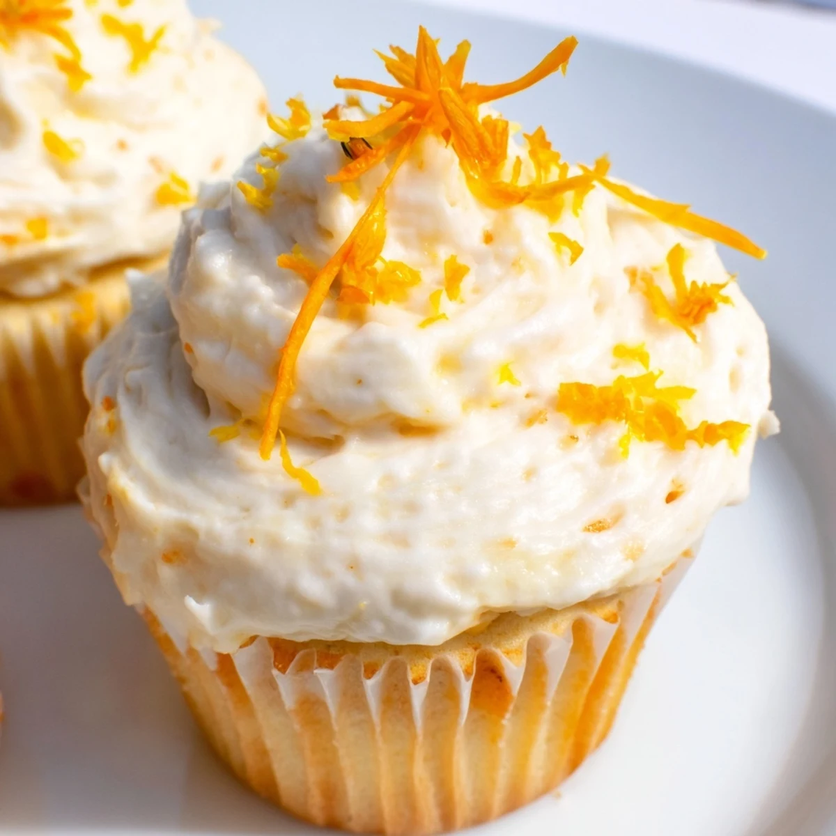 Delicate floral-infused cupcakes with smooth buttercream frosting decorated with edible flowers for spring tea parties