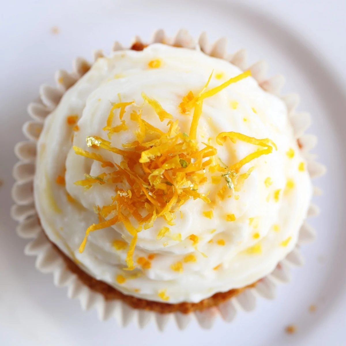 Homemade orange blossom cupcakes with aromatic orange zest and creamy frosting on vintage floral china plates
