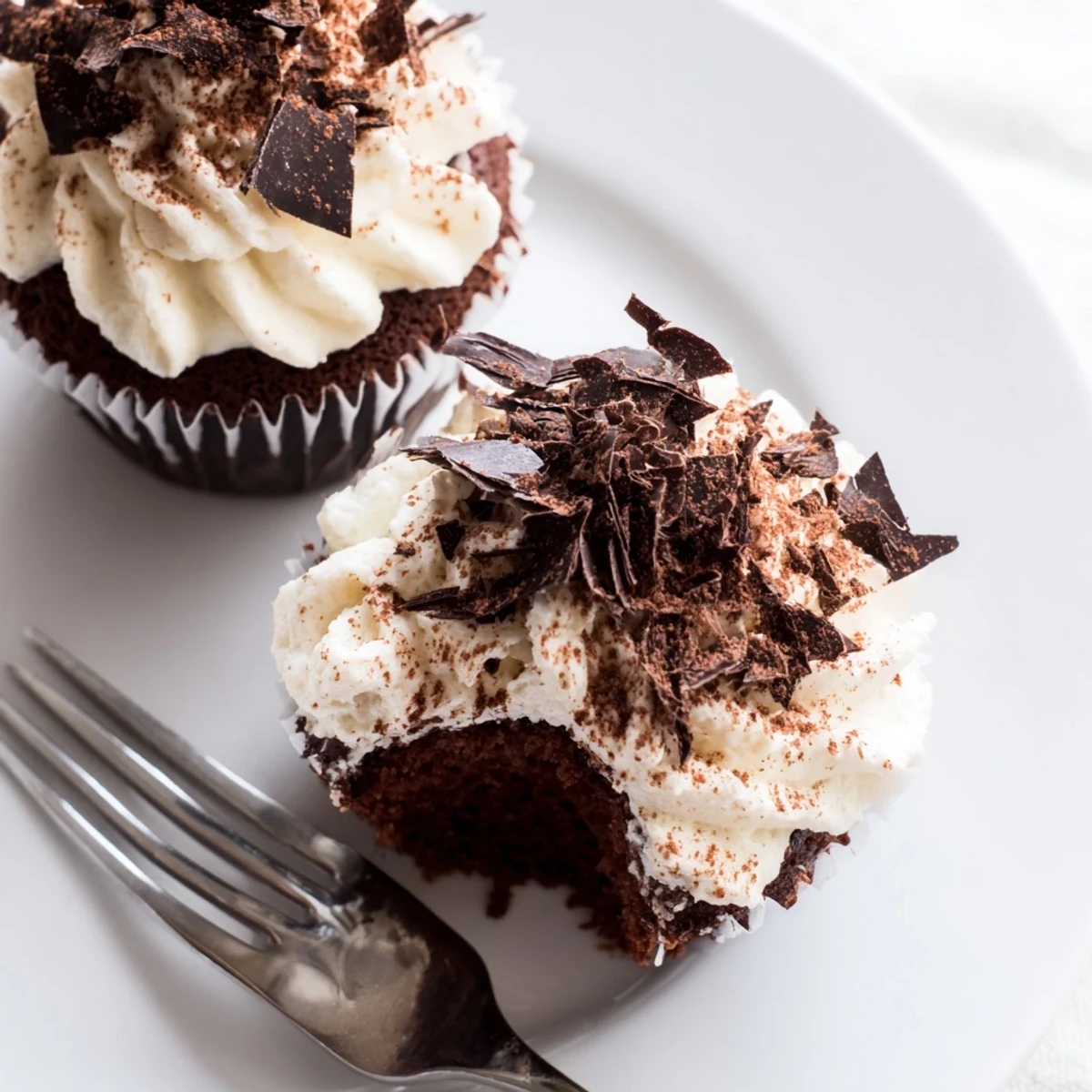 Rich chocolate tiramisu cupcakes topped with fluffy mascarpone frosting and dusted cocoa powder