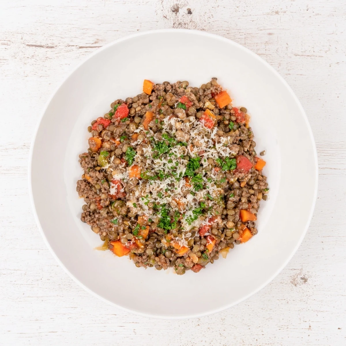 Healthy beef and lentil Bolognese sauce simmering in a pot with vibrant diced vegetables and tender lentils