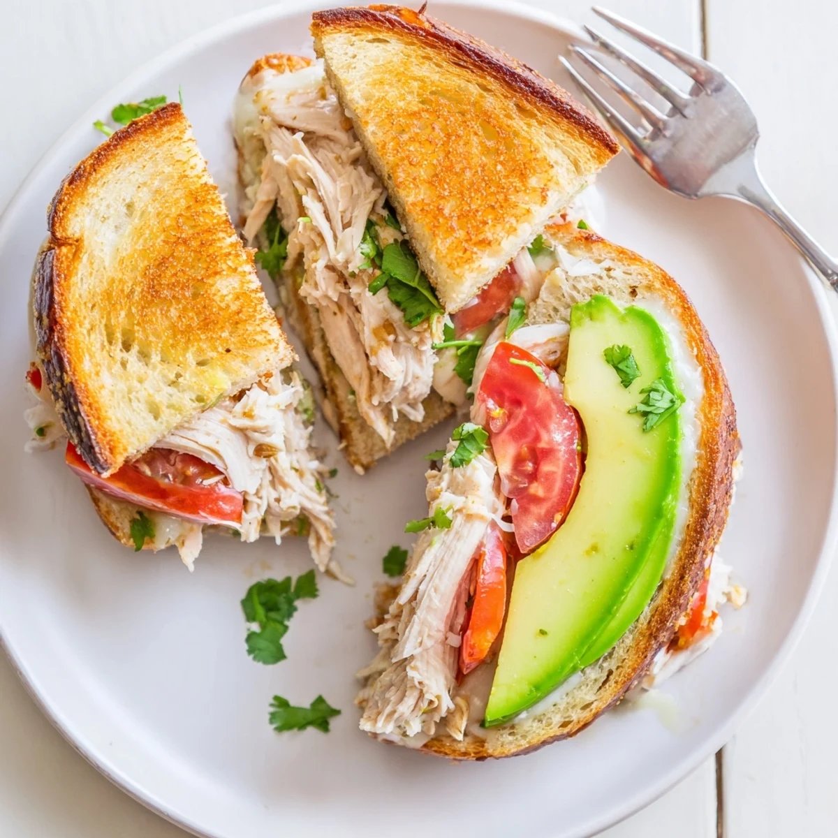 Golden grilled chicken avocado melt sandwich featuring melted provolone on sourdough bread