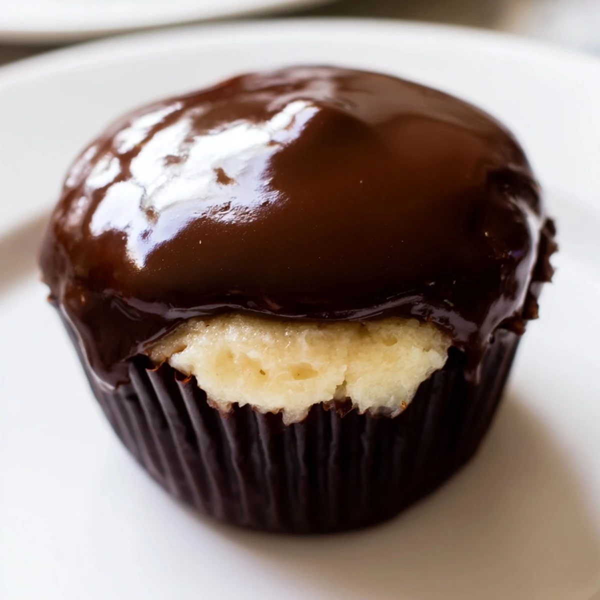 Homemade Boston cream pie cupcakes featuring moist vanilla cake, smooth pastry cream filling, and rich chocolate glaze