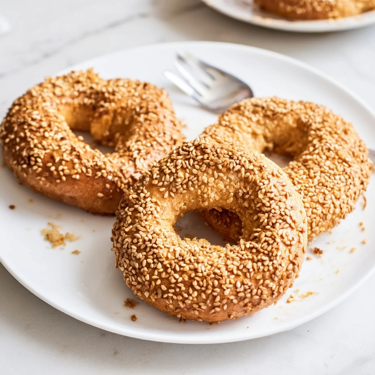 Hand-shaped Mediterranean sesame bread rings coated with toasted seeds fresh from hot oven