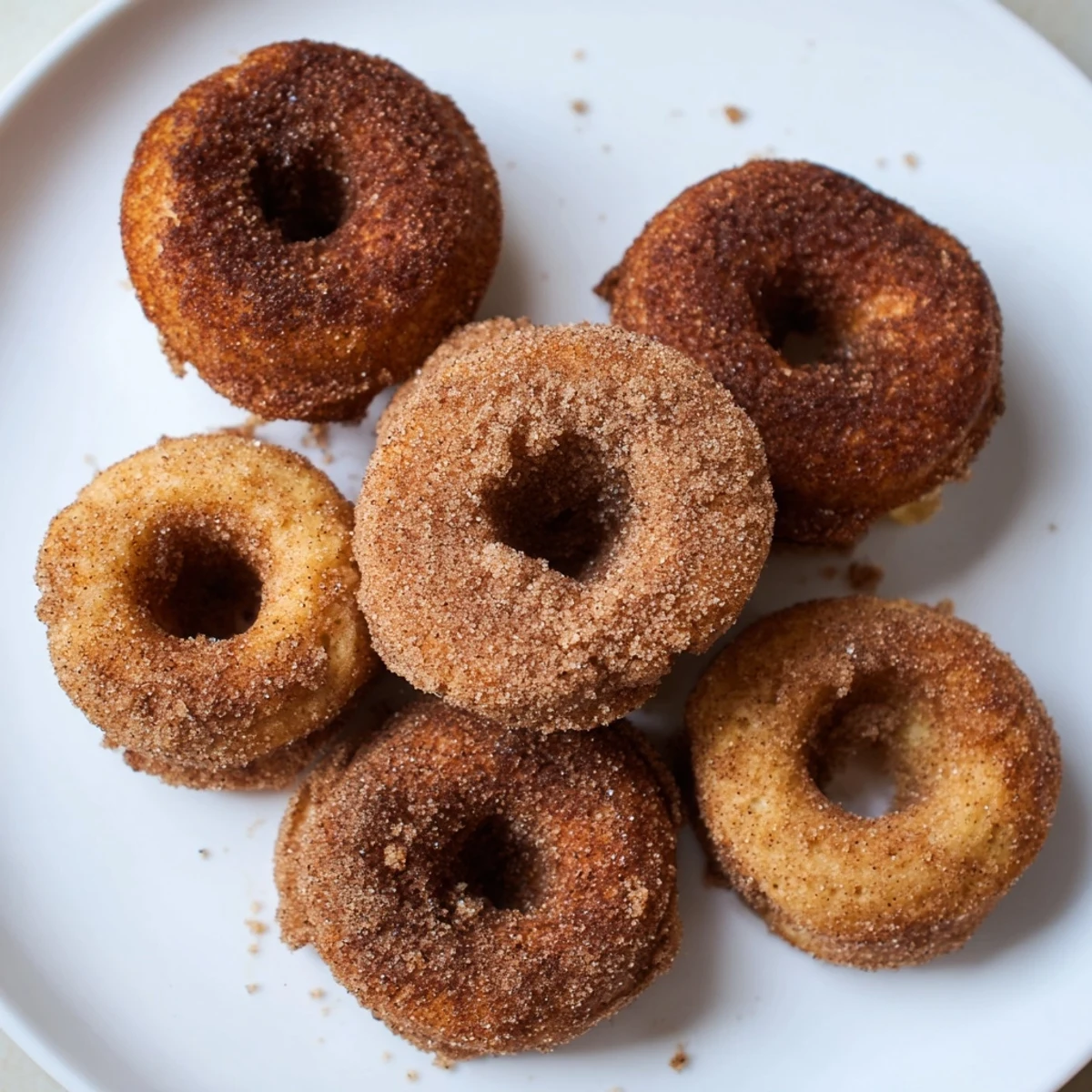 Pillowy pumpkin spice donuts dusted with cinnamon sugar coating ready for dipping