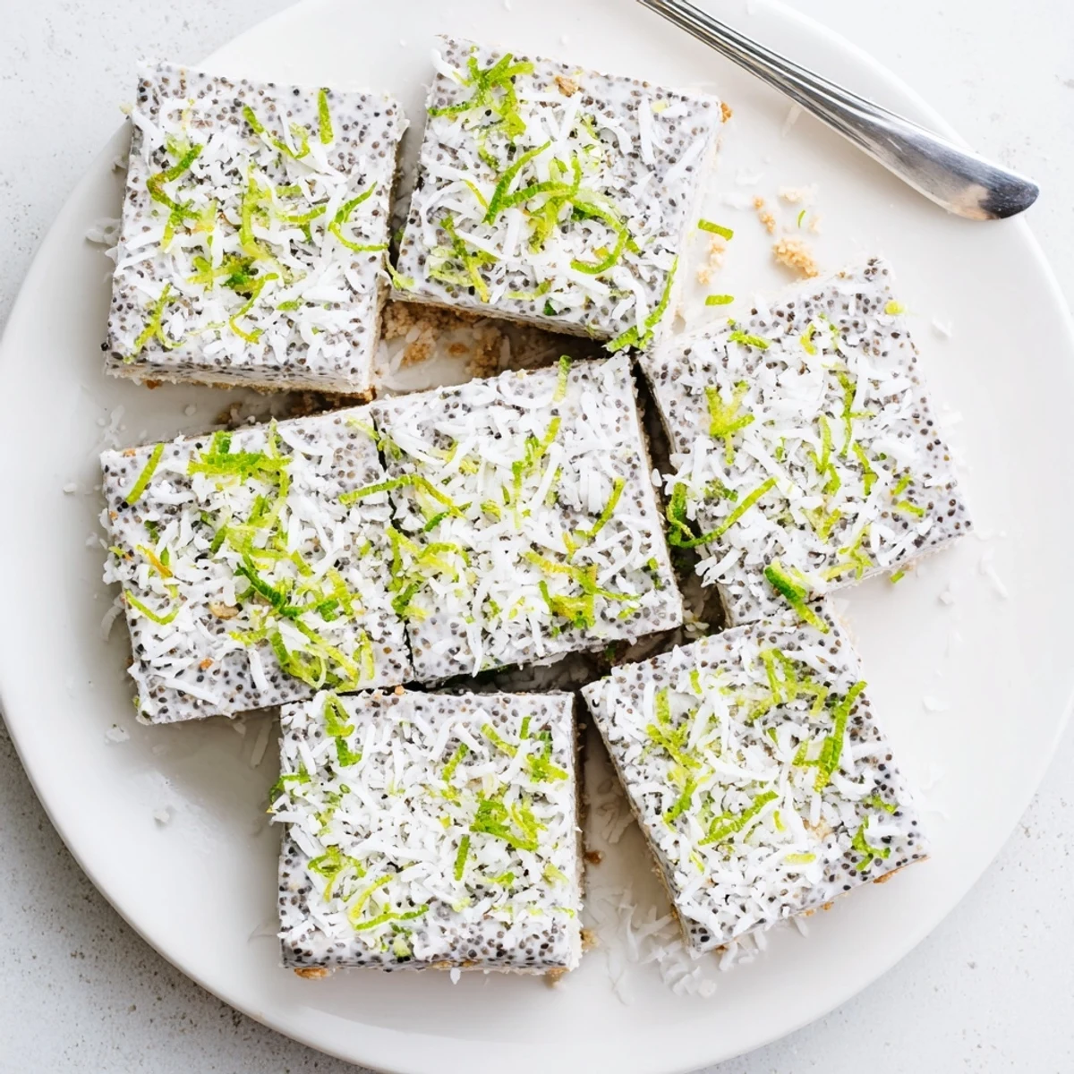 Vegan gluten-free coconut lime chia pudding bars with tangy lime zest on crumbly base