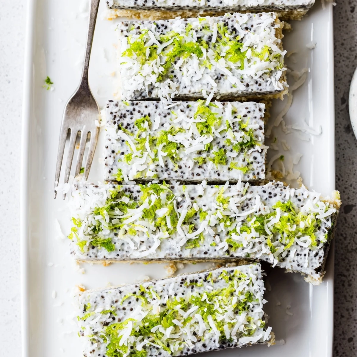 Square pan of chilled zesty coconut lime chia pudding bars sliced for easy serving