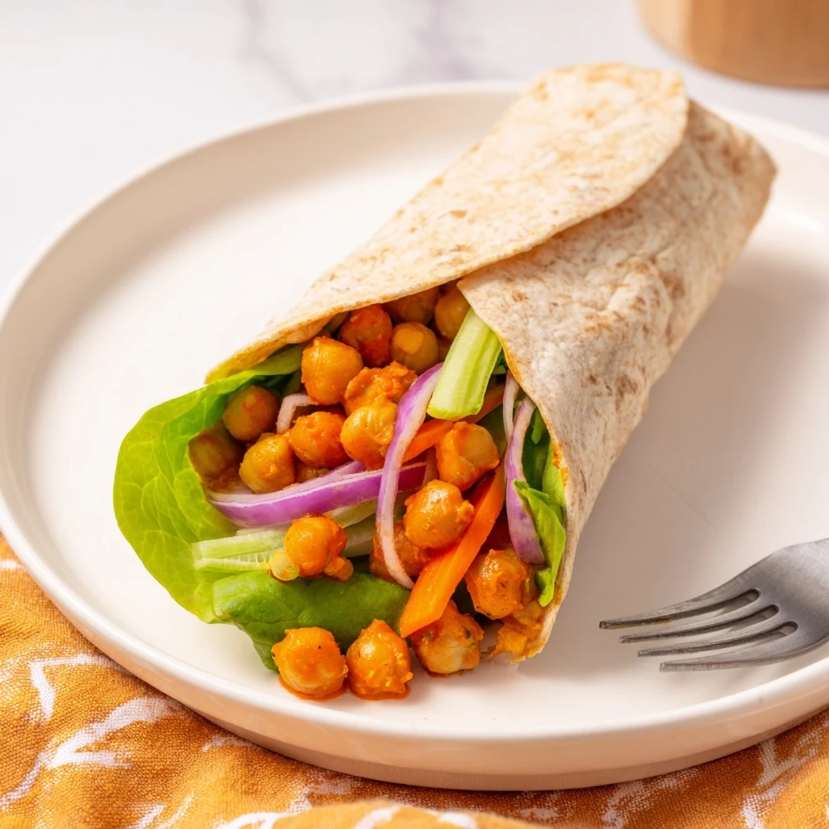 Golden buffalo chickpea wraps filled with crisp lettuce, carrots, and creamy ranch dressing