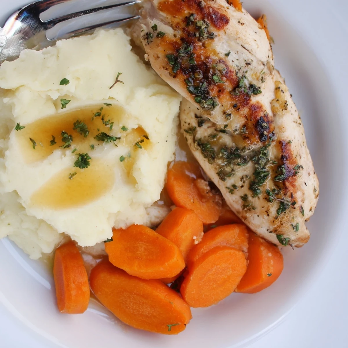 Tender herb-marinated chicken served alongside velvety buttery potatoes and sweet shiny glazed carrots for a comforting family dinner