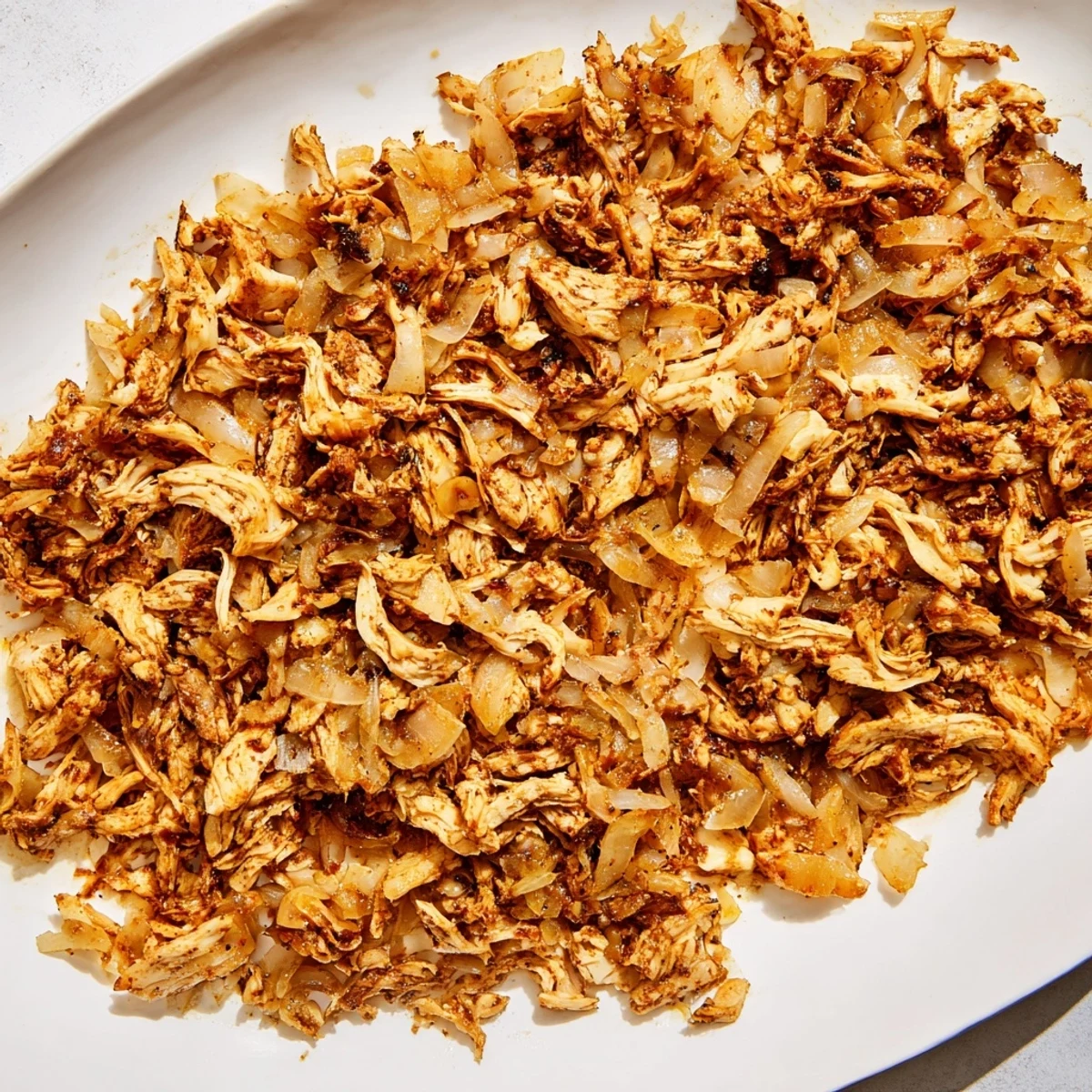 Crispy oven baked vegan carnitas made with spiced shredded mushrooms served with lime wedges and avocado