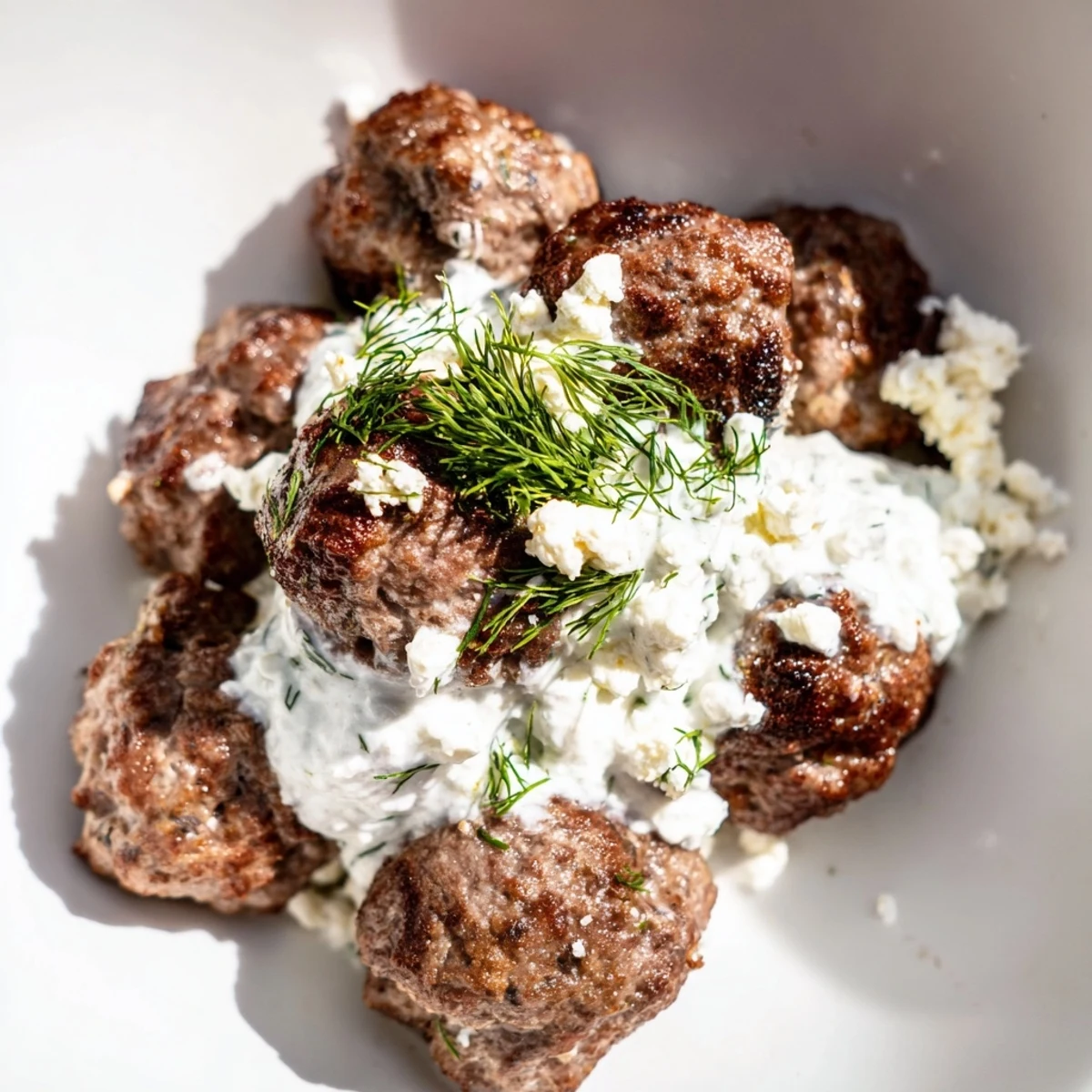 Greek meatball bowl served with tangy tzatziki, Kalamata olives, and lemon wedges