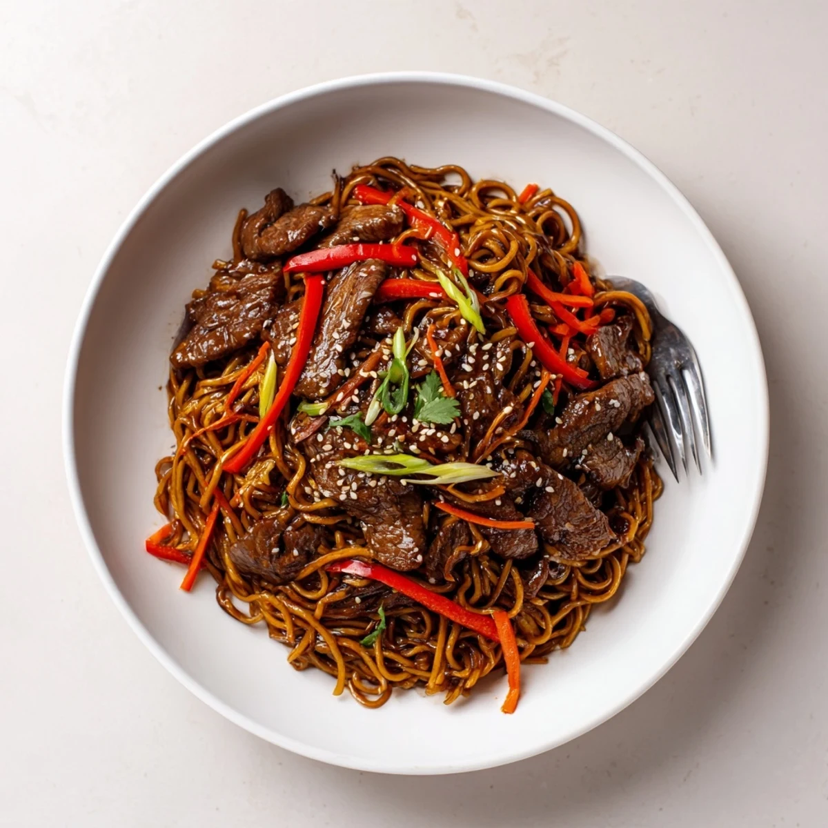 Sticky Beef Noodles glisten with glossy sauce, tender beef and sesame garnish