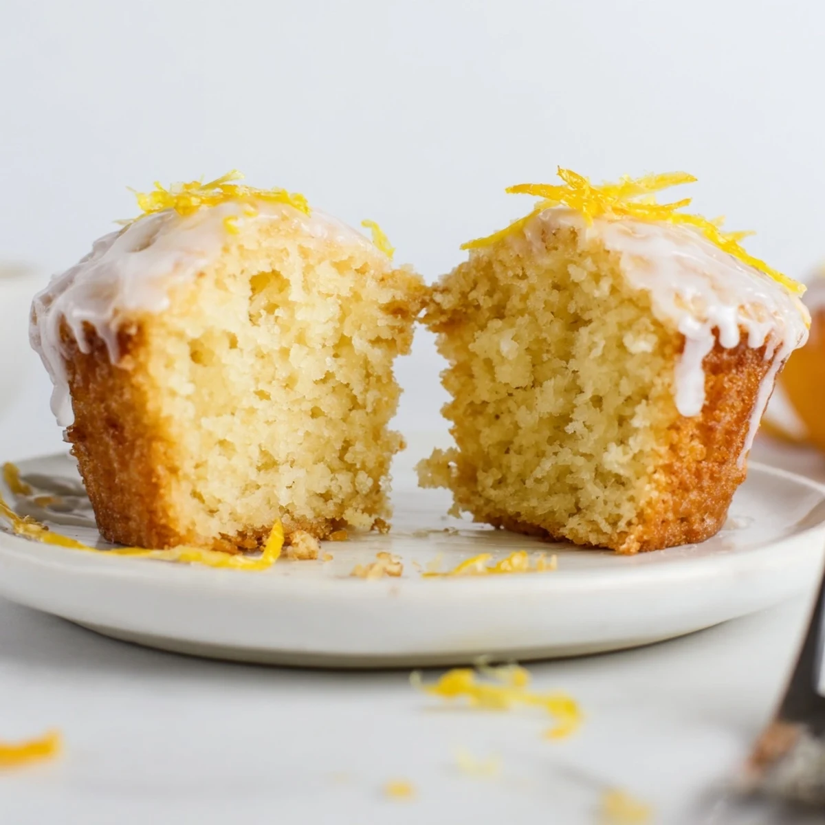 Glazed Lemon Ginger Muffins with shiny lemon glaze, steam rising, on wire rack