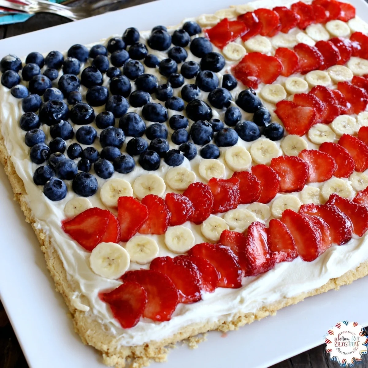 Slice of American Flag Fruit Pizza chilled with creamy frosting and strawberries