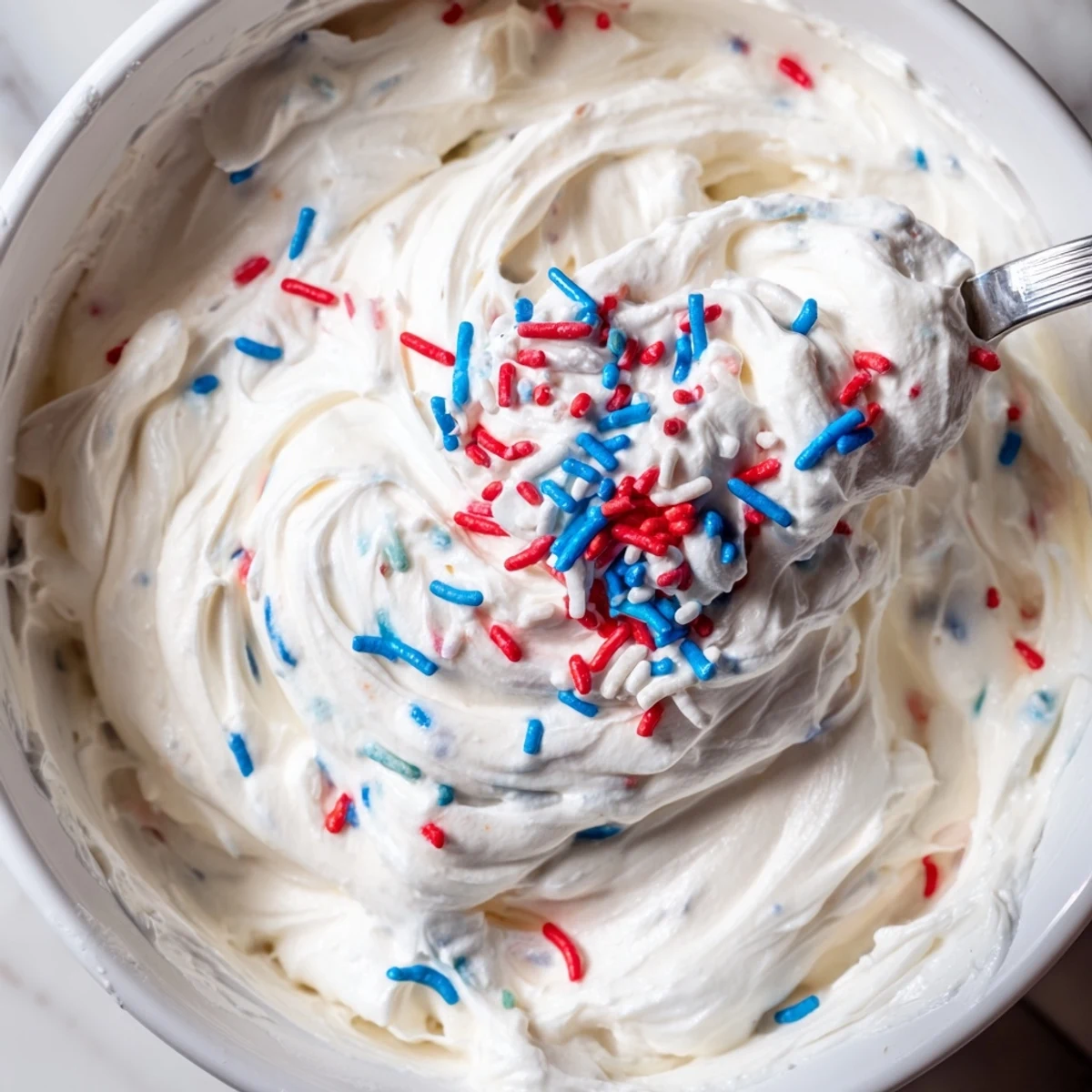 Hand-whipped Red White And Blue Funfetti Dip served with pretzels and fresh strawberries