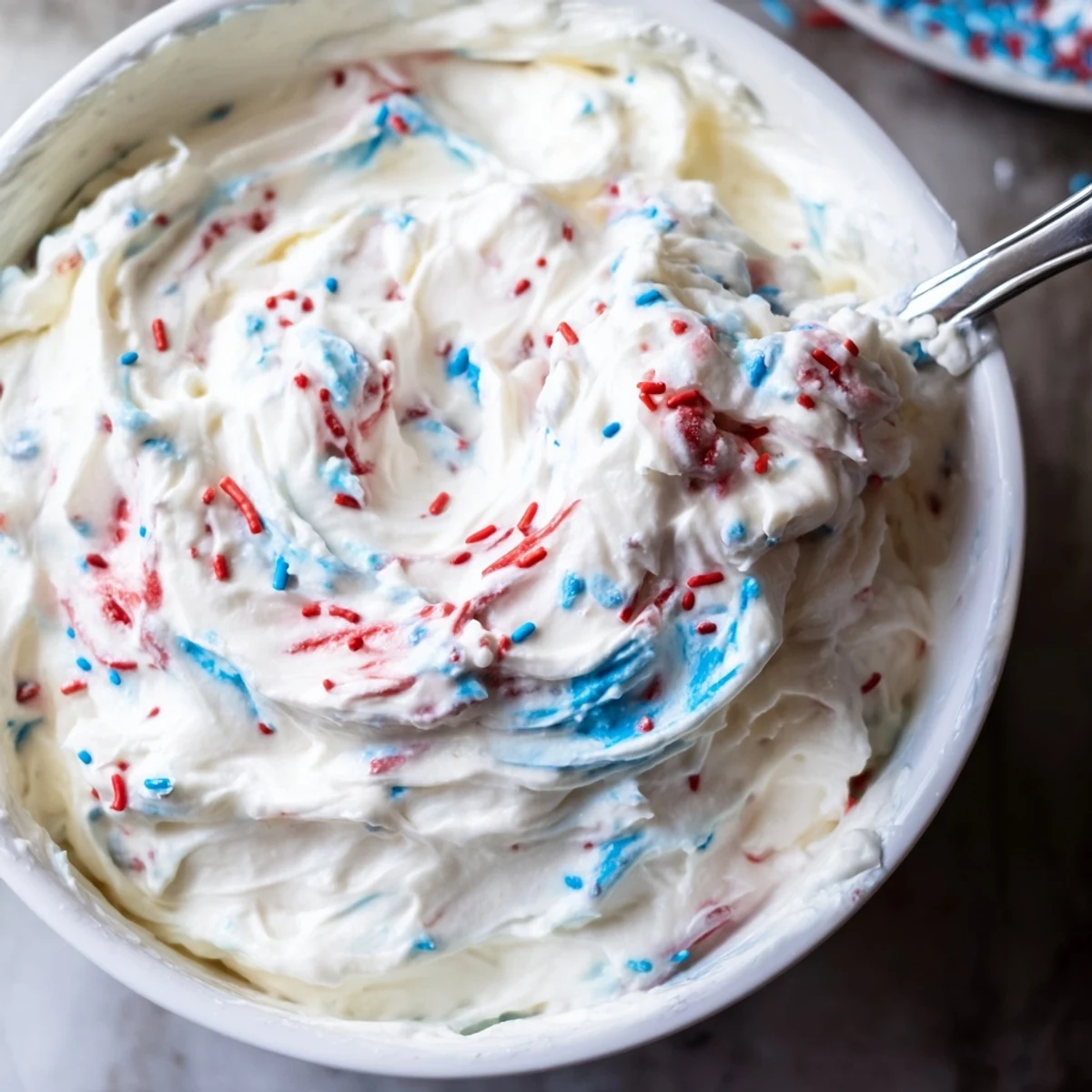 Creamy Red White And Blue Funfetti Dip topped with colorful jimmies and wafers