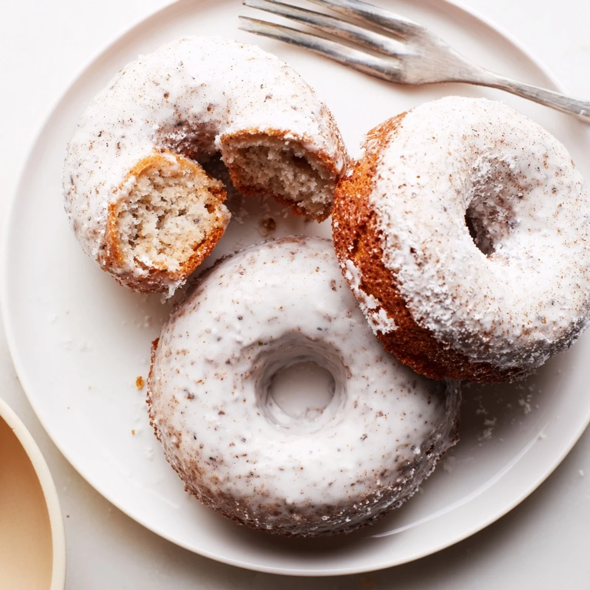 Cooling in donut pan, freshly baked Banana Donuts show golden, tender crumb.
