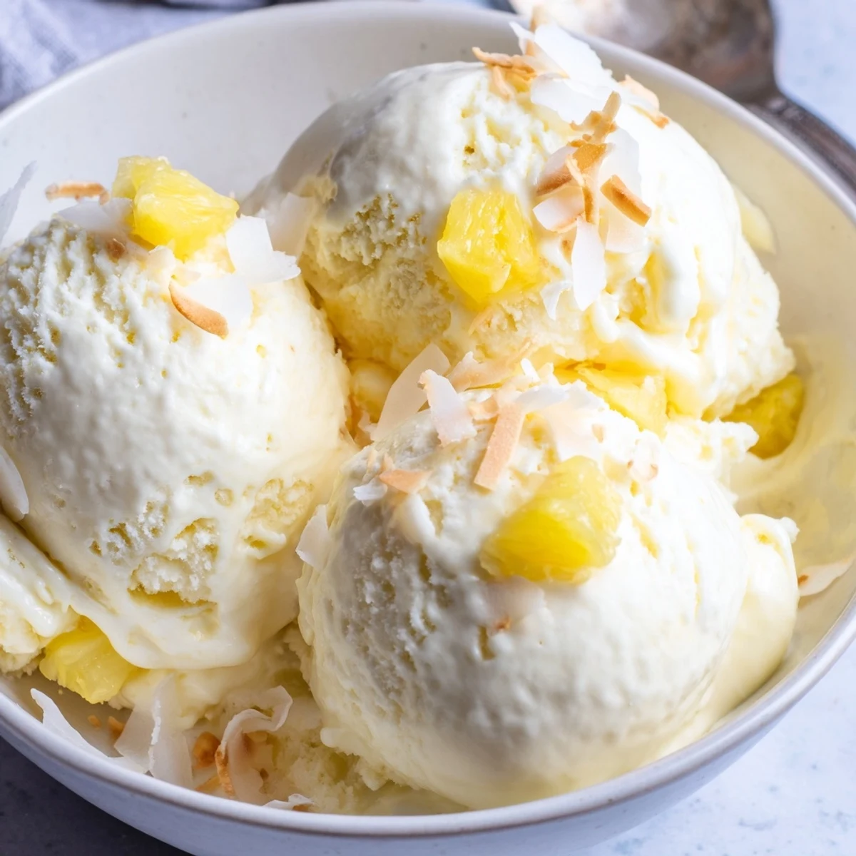 Silky Creamy Pineapple Ice Cream spoonful in bowl, cool tropical sweetness