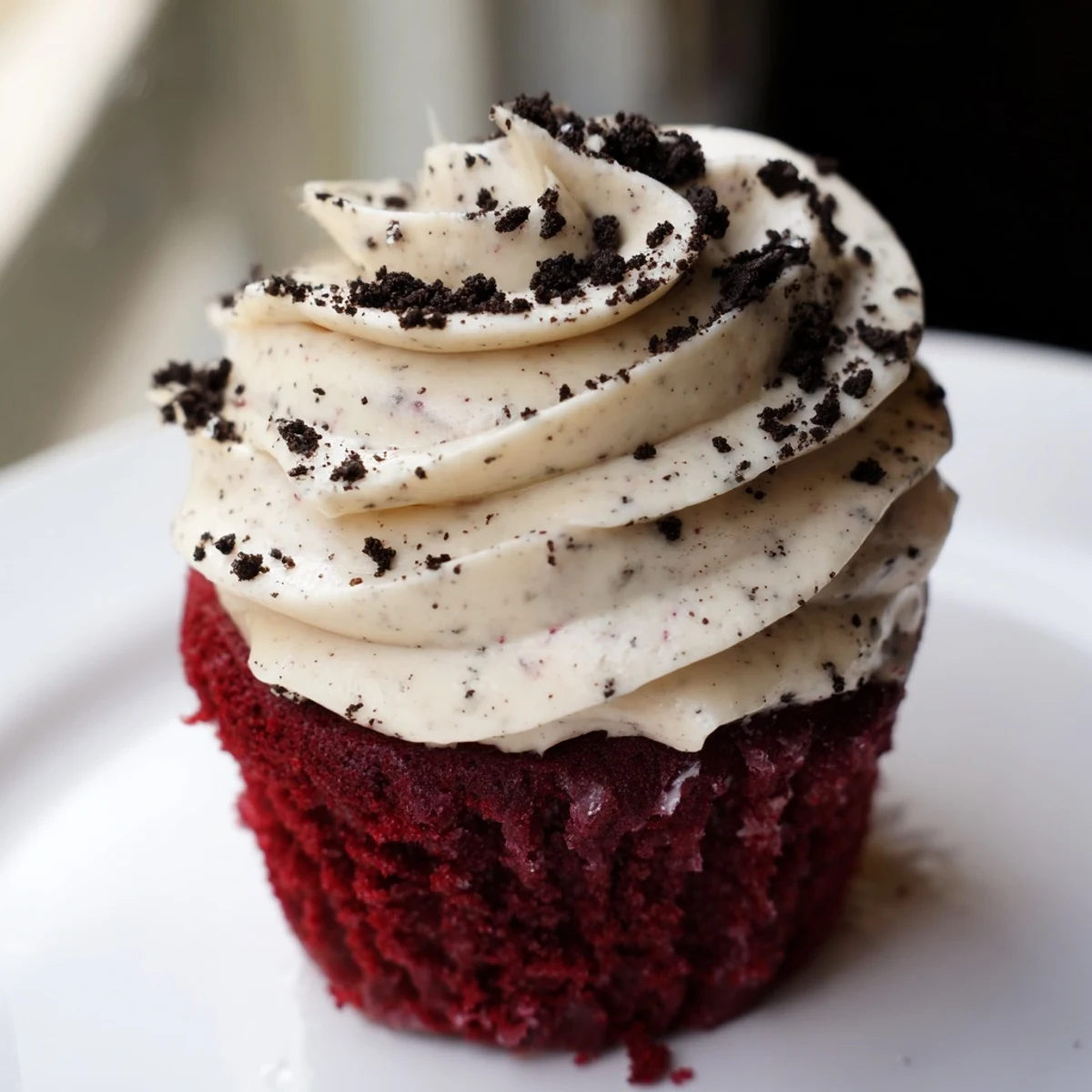 Soft red velvet Oreo cupcakes with swirls of tangy cream cheese frosting and crushed cookie garnish
