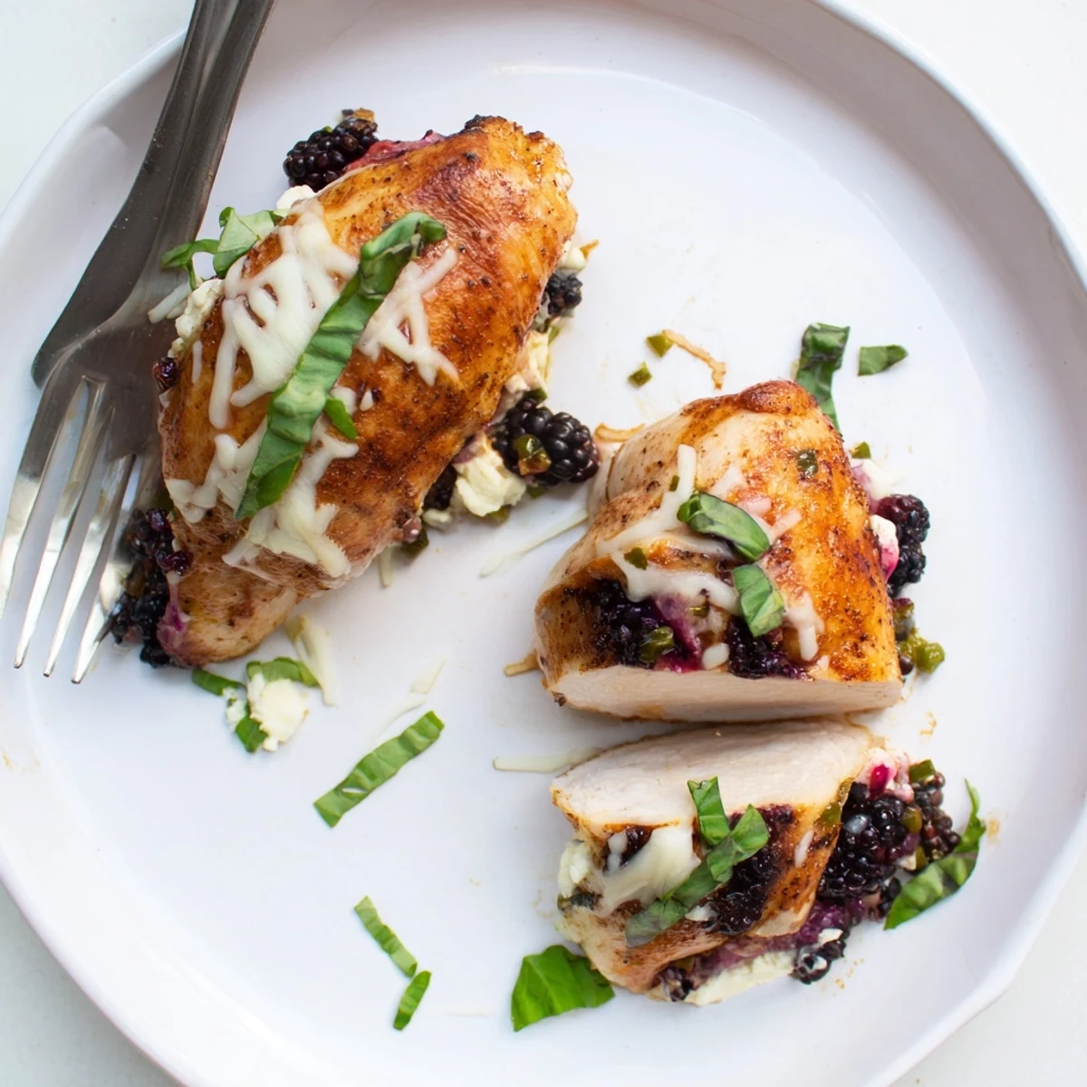 Juicy blackberry jalapeno stuffed chicken sliced open revealing creamy purple berry filling steaming hot