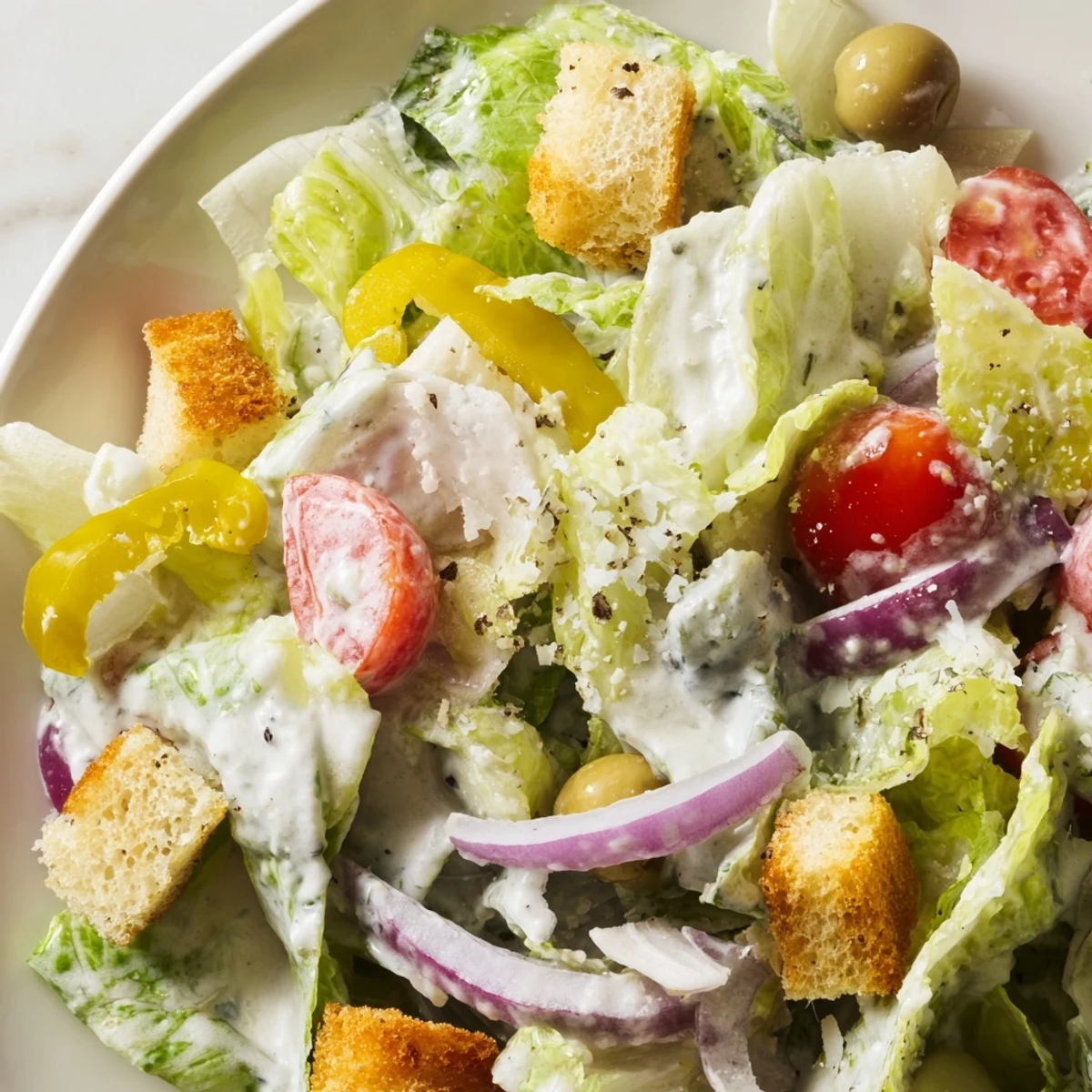 Crisp Olive Garden Salad topped with tangy pepperoncini and creamy Parmesan dressing