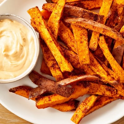 A close-up of Roasted Sweet Potato Fries with Chipotle Mayo showing smoky seasoning.